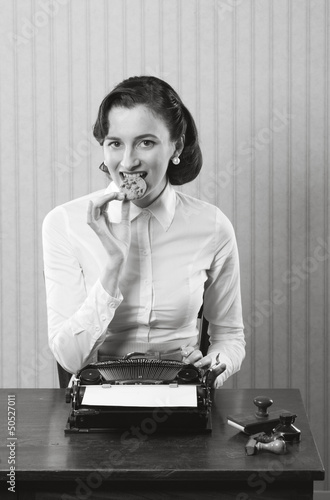 Photo: Business woman eating a cookie Business woman eating a cookie