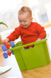 Baby in Kiste spielt mit Spielzeugauto