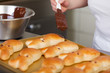 bäcker streicht schokolade auf osterhasen