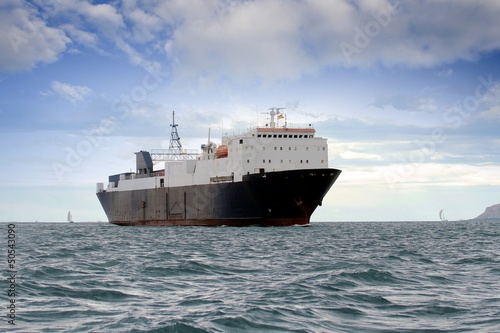 Photo: Cargo ship sailing close to coast Cargo ship sailing close to coast
