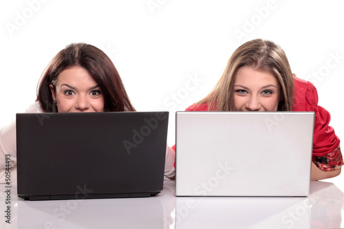 Photo: two girls having fun on their laptops two girls having fun on their laptops