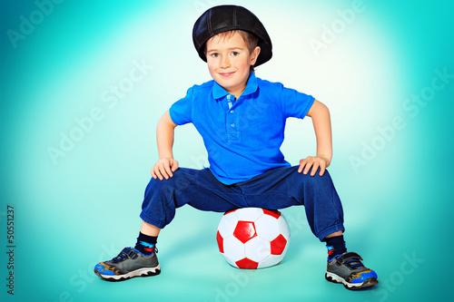 Photo: little player sitting with his ball. little player sitting with his ball.