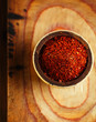 Photo: red hot chillies pepper flakes in bowl on wooden board backgro red hot chillies pepper flakes in bowl on wooden board backgro