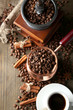 Cup of coffee, pot and grinder on wooden background