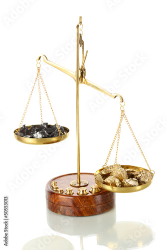 Photo: Gold and coal on scales isolated on white Gold and coal on scales isolated on white