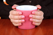 Hands holding mug of hot drink, close-up