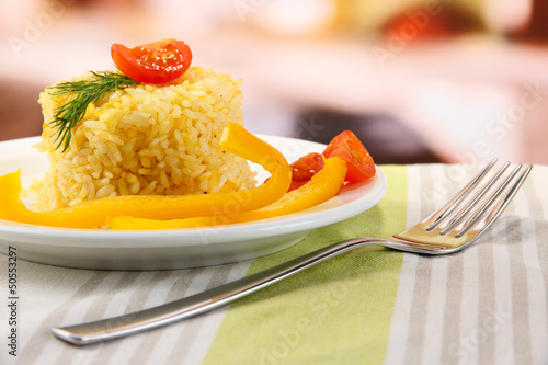 Photo: Delicious risotto with vegetables on table in cafe Delicious risotto with vegetables on table in cafe