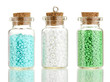Little bottles full with colorful beads isolated on white