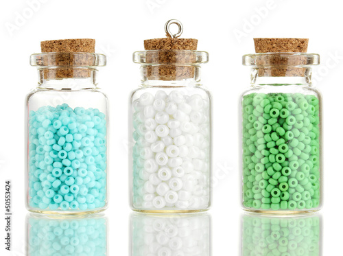 Photo: Little bottles full with colorful beads isolated on white Little bottles full with colorful beads isolated on white