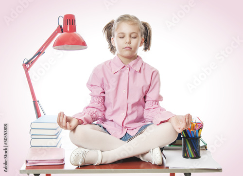 Photo: Schoolgirl meditating on the desk Schoolgirl meditating on the desk