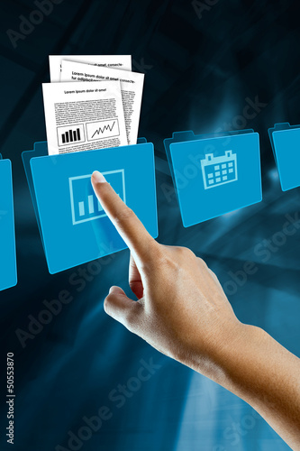 Photo: a finger of a woman, selects and opens a folder a finger of a woman, selects and opens a folder
