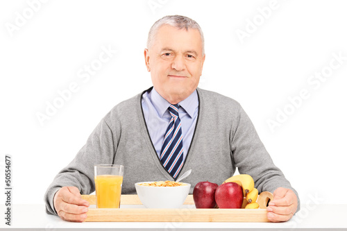 Photo: A gentleman sitting on a table with a tray full of drinks and fo A gentleman sitting on a table with a tray full of drinks and fo