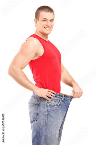 Photo: A satisfied weight loss man in a pair of old jeans A satisfied weight loss man in a pair of old jeans
