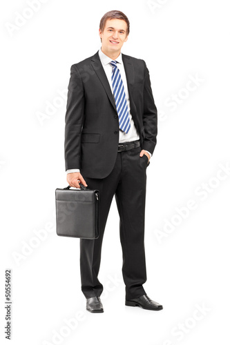 Photo: Full length portrait of a young businessman in suit holding a su Full length portrait of a young businessman in suit holding a su