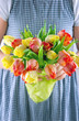 Little girl handing a bouquet of tulips