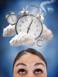 Woman looking up at ringing alarm clocks in clouds