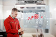 Mechanic holding a clipboard with a futuristic interface next to