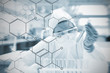 Chemist working cautiously with liquid and futuristic interface