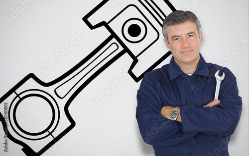 Photo: Mature mechanic standing next to car symbol Mature mechanic standing next to car symbol