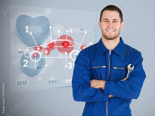 Photo: Portrait of a young mechanic next to futuristic interface Portrait of a young mechanic next to futuristic interface