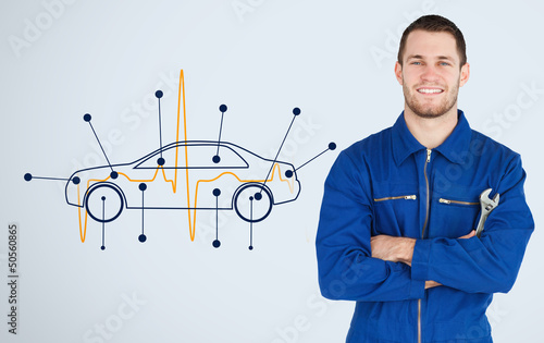Photo: Portrait of a young mechanic next to background with car Portrait of a young mechanic next to background with car
