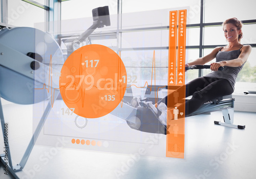 Photo: Young girl on rowing machine with futuristic interface showing c Young girl on rowing machine with futuristic interface showing c