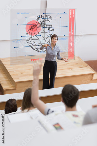 Photo: Teacher in front of futuristic interface pointing a student Teacher in front of futuristic interface pointing a student