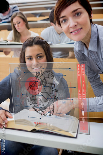 Photo: Teacher and student looking futuristic interface during lecture Teacher and student looking futuristic interface during lecture