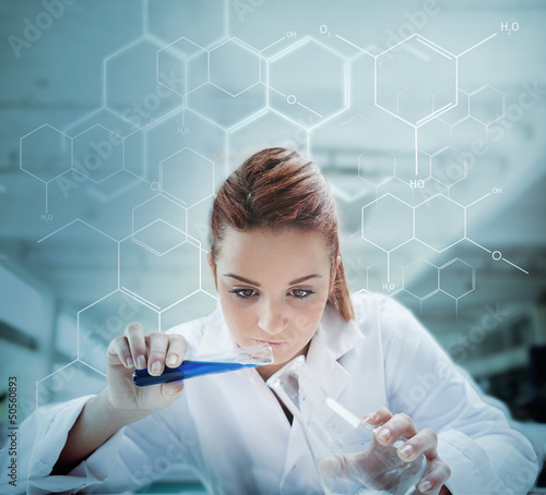 Photo: Scientist pouring liquid into erlenmeyer with futuristic screen Scientist pouring liquid into erlenmeyer with futuristic screen