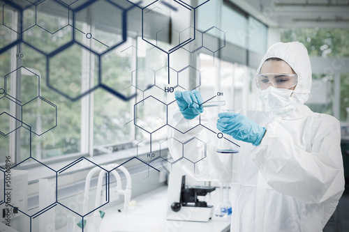 Photo: Chemist in protective suit working with futuristic interface wit Chemist in protective suit working with futuristic interface wit