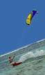 Speedy surfing man, colorful kite.