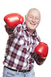 Senior man wearing boxing gloves smiling