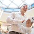 Foto: Businessman with tablet computer in modern business building Businessman with tablet computer in modern business building