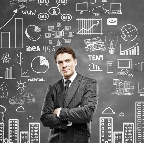 Photo: man standing and drawing business concept on wall man standing and drawing business concept on wall