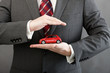 Red car in hands of businessman . Concept of the best insurance