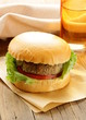 burger with tomatoes and pickled cucumbers on a wooden table