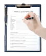 Hand with a pen filling in medical questionnaire form
