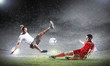 two football players striking the ball