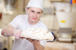 bäcker schiebt brot in den ofen