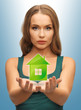 woman holding green house in her hands