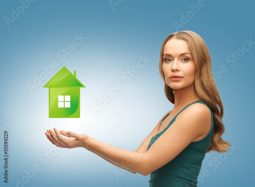 Photo: woman holding green house in her hands woman holding green house in her hands