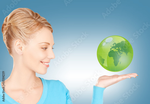Photo: woman holding green globe on her hand woman holding green globe on her hand