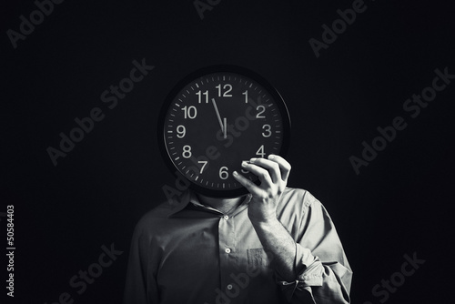 Photo: Businessman with black clock, deadline concept Businessman with black clock, deadline concept