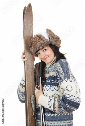 Photo: young woman in winter clothes holding old wooden skis young woman in winter clothes holding old wooden skis