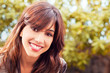 Photo: Portrait of a brunette girl outdoors on a green background Portrait of a brunette girl outdoors on a green background