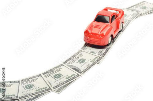 Photo: Toy car moving on a US paper currency road Toy car moving on a US paper currency road