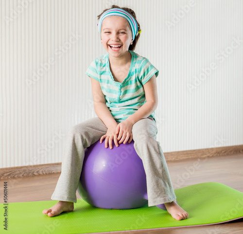 Photo: little girl doing gymnastic exercises little girl doing gymnastic exercises