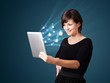 Young woman looking at modern tablet with abstract lights and so