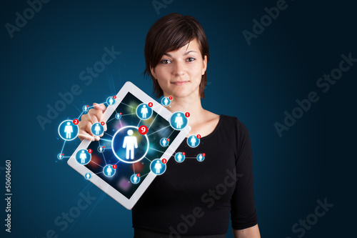 Photo: young woman holding tablet with social network icons young woman holding tablet with social network icons