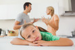 Angry couple arguing behind a sad girl